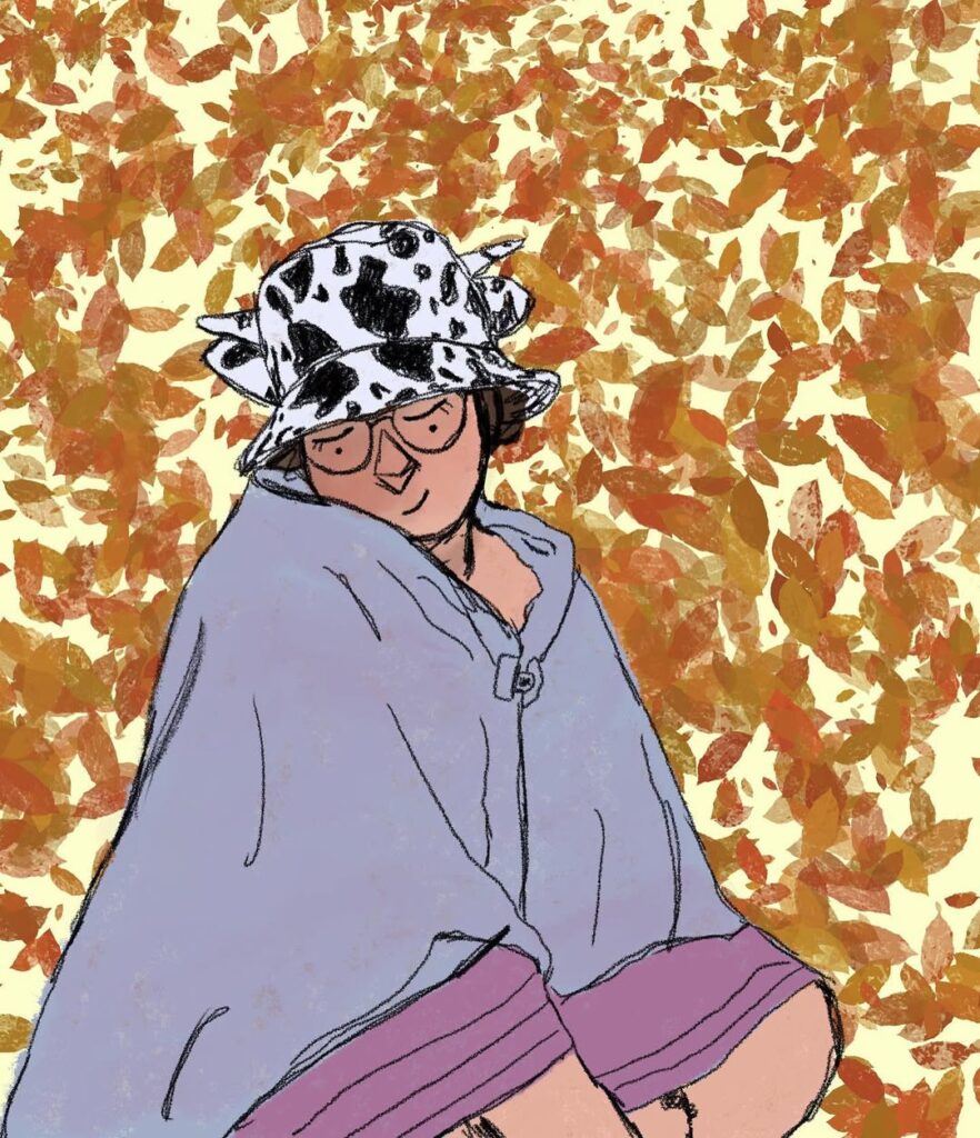 Autorretrato ilustrado sentada entre hojas de otoño