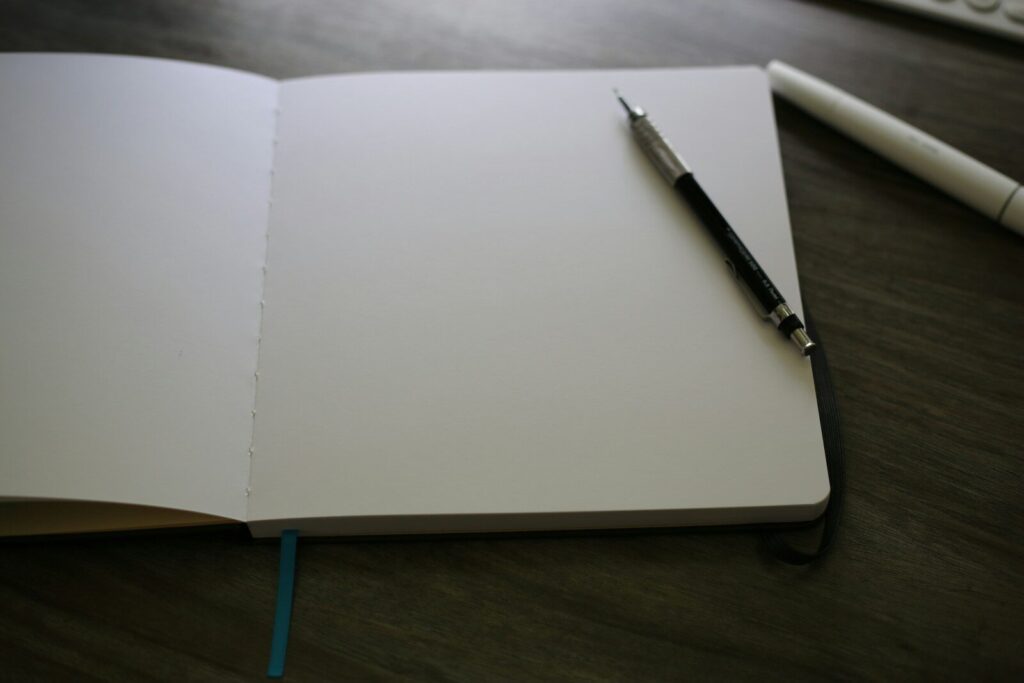 Materiales para empezar a ilustrar sin gastarte un sueldo 1 Cuaderno de papel abierto con un bolígrafo encima
